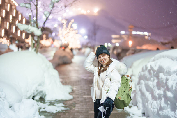 冬は雪が降るニセコ市の女性観光客。北海道の観光スポットとして人気のランドマーク。旅行と休暇のコンセプト - 写真・画像