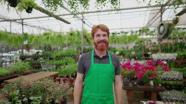 Portrait of a Smiling Red-Haired Male Employee smiling at camera in Flower Shop - Foto, immagini