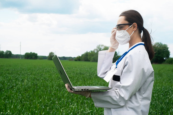 Agronomist using tablet and technology in agricultural corn field. The farmer walks through the field with a tablet. Biologist woman with laptop - Photo, Image