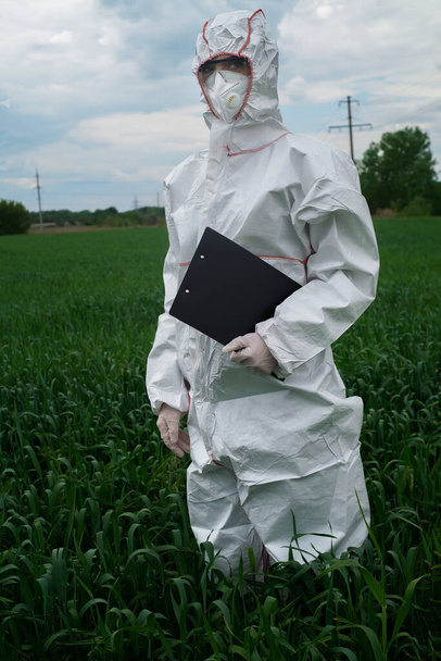 вчений у захисному білому костюмі PPE, лікує розсаду, розбризковує листя добривами та бореться з інфекційними захворюваннями, вирощує гриби під штучним світлом в теплиці, концепції біотехнологій. Харчові технології. харчування науки
. - Фото, зображення