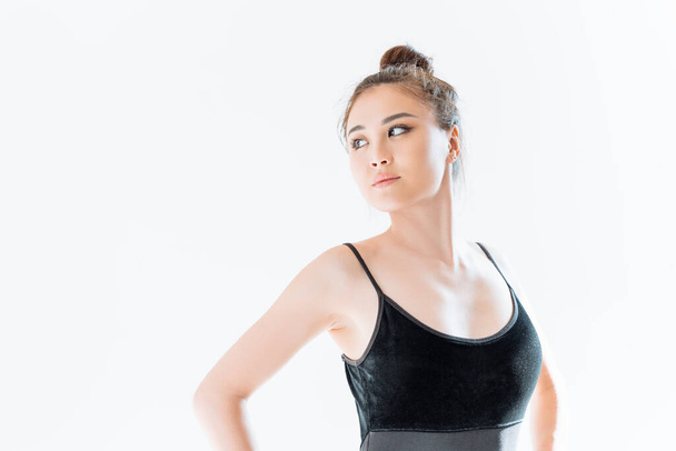 Beautiful sporty woman in black sportswear posing on white background with copy space. Studio photography. - 写真・画像