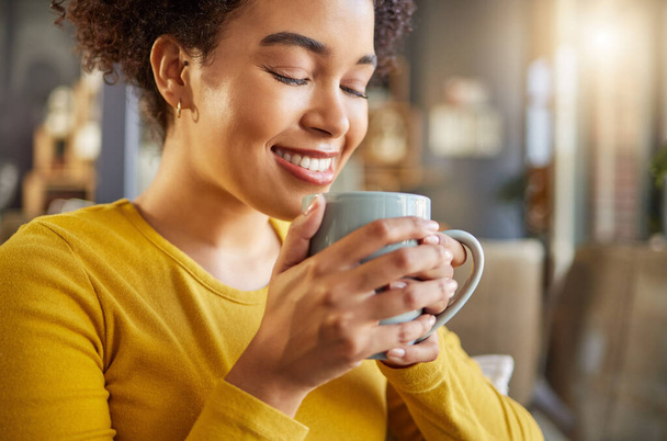 Africká žena, šálek kávy a šťastný na gauči, vůně nebo energie začít ráno v bytě. Dívka, úsměv a teplý nápoj pro relaxaci s coco, matcha nebo espresso pro vůni, myšlení a hrnek v domě. - Fotografie, Obrázek
