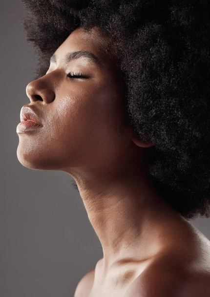 Natural hair care, profile and black woman with afro hairstyle, beauty and skincare on grey background. Natural haircare, cosmetics and face closeup of African model with skin glow or shine in studio. - Fotografie, Obrázek