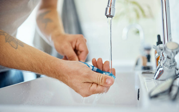 Hands, toothbrush or man at sink of water, dental hygiene or wellness of gum care at home. Closeup of person washing oral product for brushing teeth, fresh morning routine or cleaning at bathroom tap. - Foto, Imagem