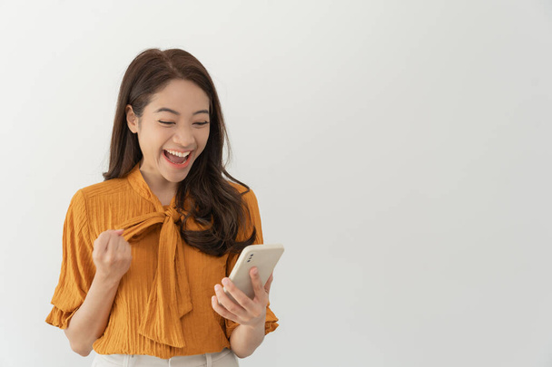 Asian beautiful woman exited surprise face expression . female feels shocked. exciting smile and happy adorable rejoices. Very enjoy and fun relax time. wow, girl holding smartphone. Smile. - Fotó, kép