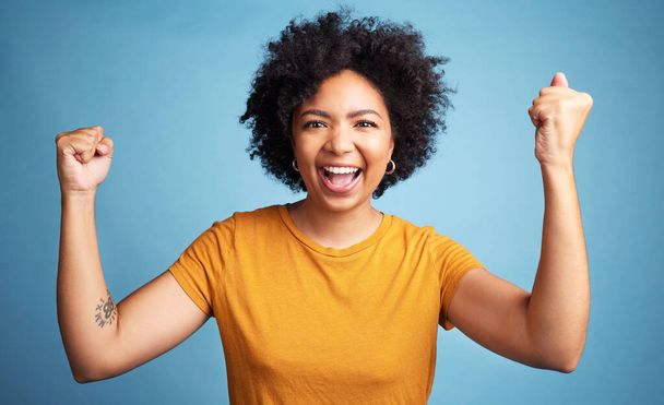 Winner portrait, yes and woman isolated on blue background in winning, success and news or college opportunity. Celebrate, fist or power of african person or excited student energy or goals in studio. - Foto, immagini