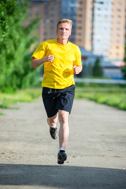 Sporty man jogging in city street park - Zdjęcie, obraz