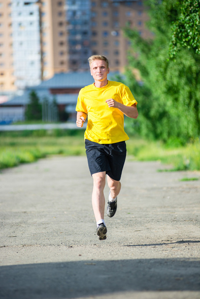 Sportlicher Mann joggt im Stadtpark - Foto, Bild