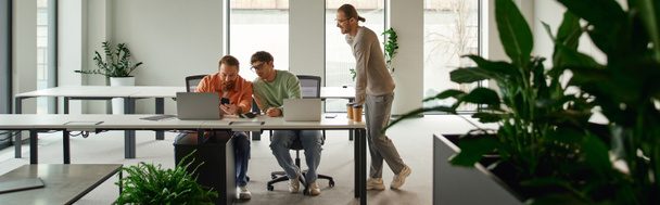 vállalkozó alkalmi ruhák áll kollégák mellett dolgozik az új üzleti projekt közelében számítógépek modern irodai környezetben high-tech belső és természetes növények, banner - Fotó, kép