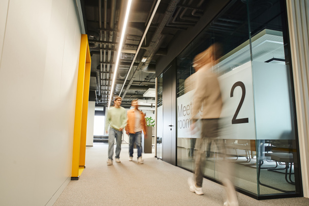 Modern iş adamlarının hareket bulanıklığı üst düzey teknoloji içerikli, dinamik iş konseptiyle çağdaş çalışma ortamındaki toplantı odası boyunca koridorda çalışmaları - Fotoğraf, Görsel