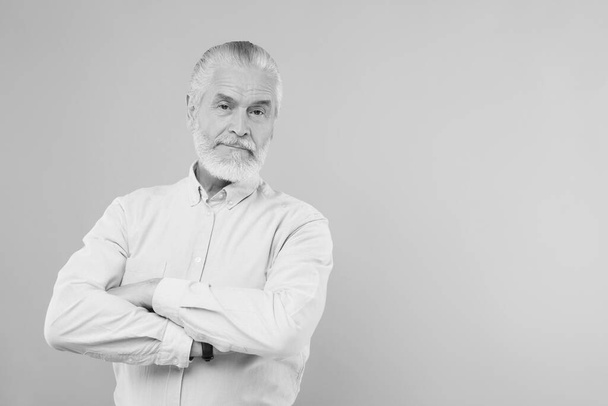 Portrait of handsome senior man on light background, space for text. Black and white effect - Foto, Imagem