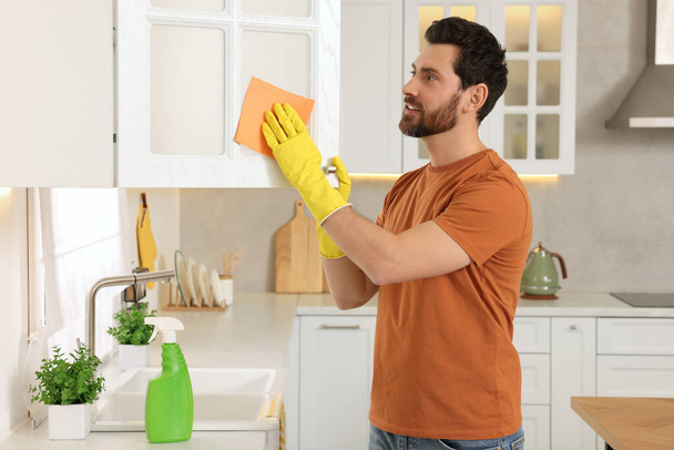 Frühjahrsputz. Mann räumt Küche zu Hause auf - Foto, Bild