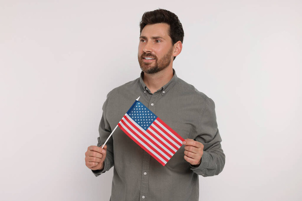 4 lipca - Dzień Niepodległości USA. Szczęśliwy człowiek z amerykańską flagą na białym tle - Zdjęcie, obraz