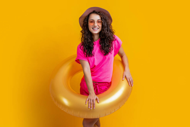 happy summertime girl with inflatable ring isolated on yellow. summertime girl with inflatable ring in studio. summertime girl with inflatable ring. photo of summertime girl with inflatable ring. - Foto, immagini