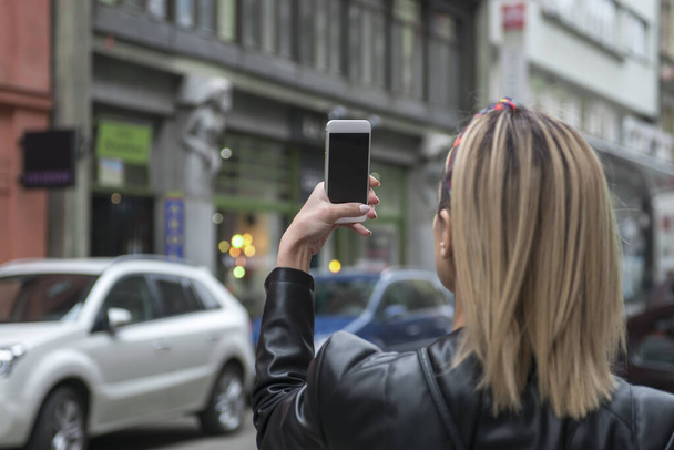 Donna turista scattare foto con fotocamera mobile in strada - Foto, immagini