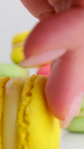 mano femenina juega bolos con macarons empuja macarons amarillos con los que derriba todos los dulces se dispersan en diferentes direcciones sabroso apetitoso interesante  - Metraje, vídeo