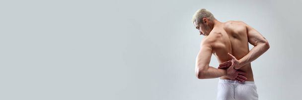 Cropped image of beautiful, strong, muscular, relief males back against grey studio background. Concept of male natural beauty, body care, health, sport, fashion. Banner. Copy space for ad - Фото, изображение