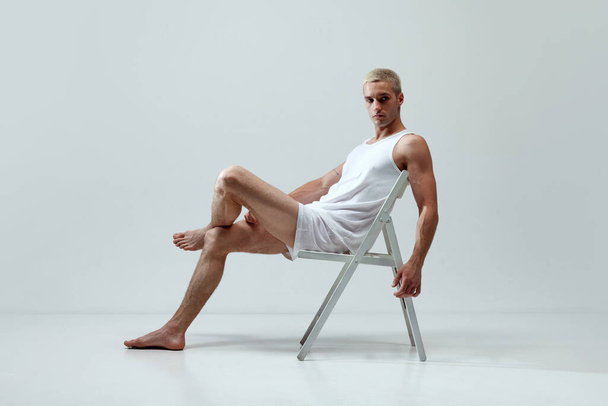 Comfort look. Young handsome man with muscular body posing in underwear and singlet against grey studio background. Concept of male natural beauty, body care, health, sport, fashion, ad - Fotó, kép