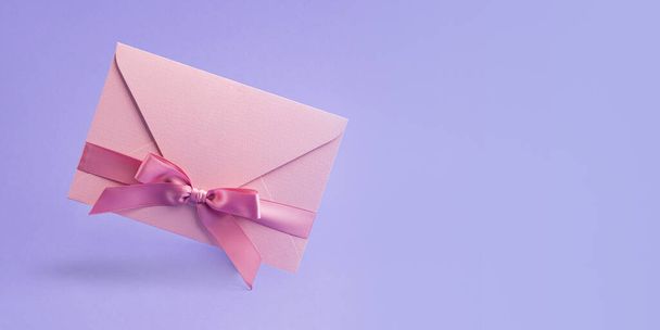 Pinnk certificate gift with satin ribbon on lavender background.Large banner with negative space. - Fotó, kép