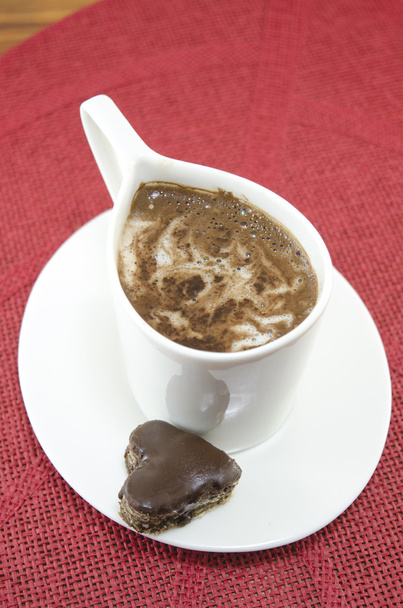 White cup of coffe and a heart shaped candy - Photo, Image