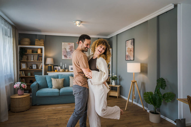 Happy couple adult caucasian man and woman husband and wife dance at home - Photo, Image
