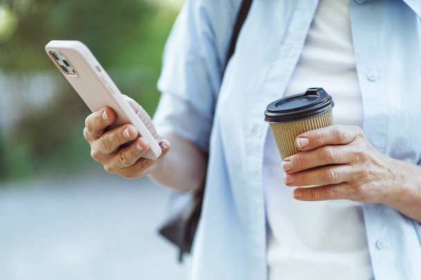 Kuppi kahvia rinnalla älypuhelin, symboloi yhdistelmä digitaalisen viestinnän ja ilo kahvin kulutusta. Kahvi ja mobiili viestintä internetissä käsite. Laadukas kuva - Valokuva, kuva