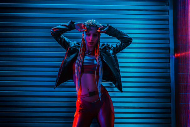 Young woman dancer posing in dark night club interior with neon lights - Fotografie, Obrázek