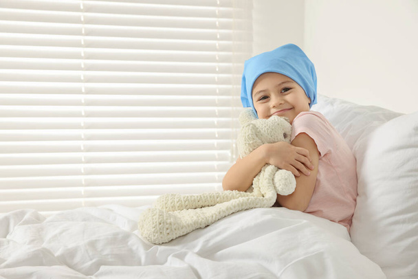 Childhood cancer. Girl hugging toy bunny in hospital - Foto, afbeelding