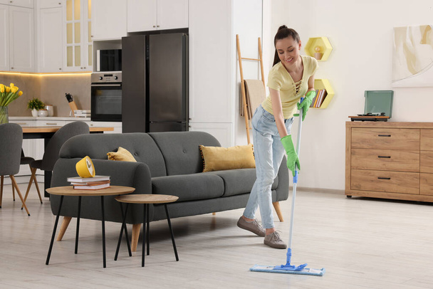Spring cleaning. Young woman with mop washing floor at home - Foto, Bild