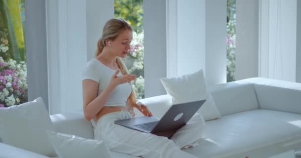 Χαμογελαστή γυναίκα των επιχειρήσεων μιλήσουμε με τους επιχειρηματικούς εταίρους σε φορητό υπολογιστή online εφαρμογή τηλεδιάσκεψης, κάθεται στον καναπέ στο σπίτι. Επιχειρηματίας μιλάμε φορητό υπολογιστή εικονική συνάντηση κλήσης στο σπίτι μιλούν συνέντευξη για δουλειά. - Πλάνα, βίντεο