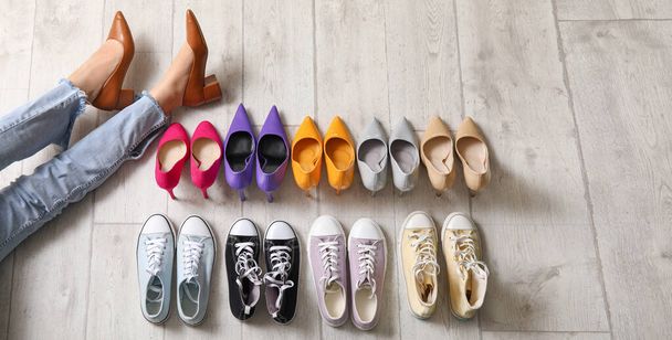 Pernas femininas com diferentes sapatos elegantes no chão, vista superior - Foto, Imagem