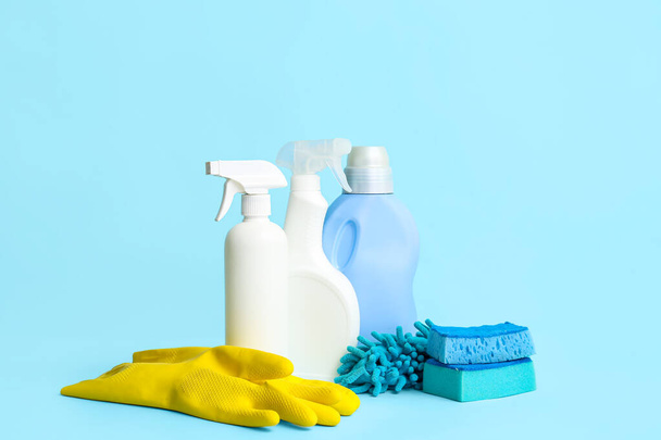 Different cleaning supplies on blue background - Foto, Imagen