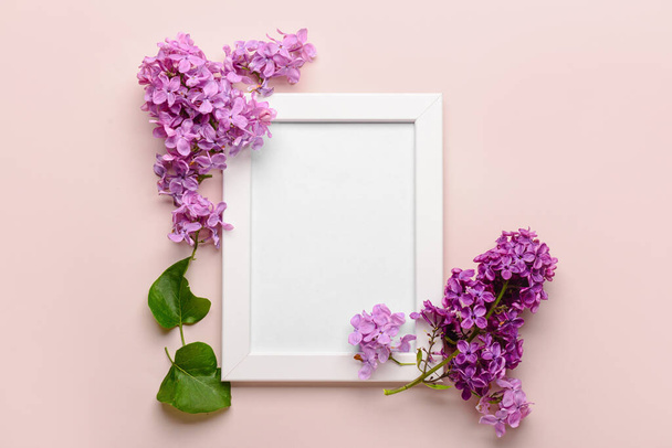 Composition with beautiful lilac flowers and blank frame on beige background - 写真・画像
