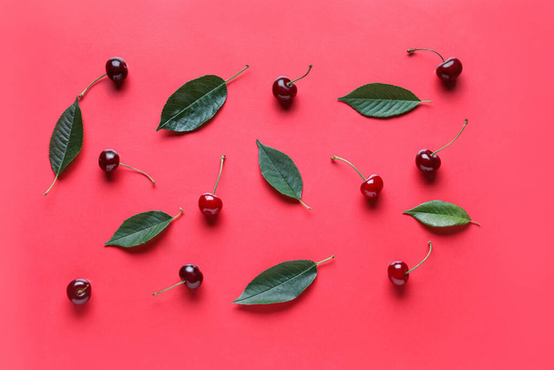 Wiśnie i liście na czerwonym tle - Zdjęcie, obraz