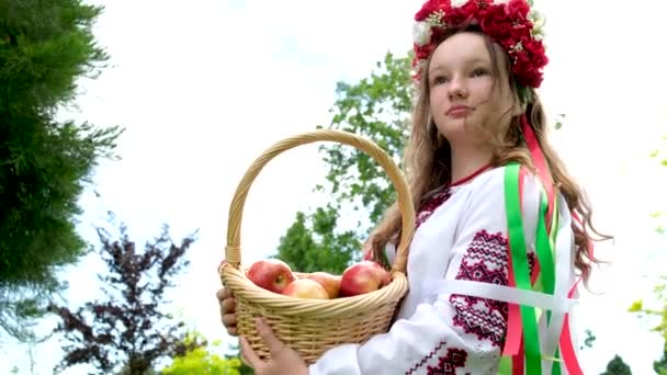 Красивая девушка смотрит через корзину с ягодами Роуэна в руках и улыбается. Портрет красивой женщины рядом с роуэн-деревом. Традиционный костюм. Высокое качество - Кадры, видео