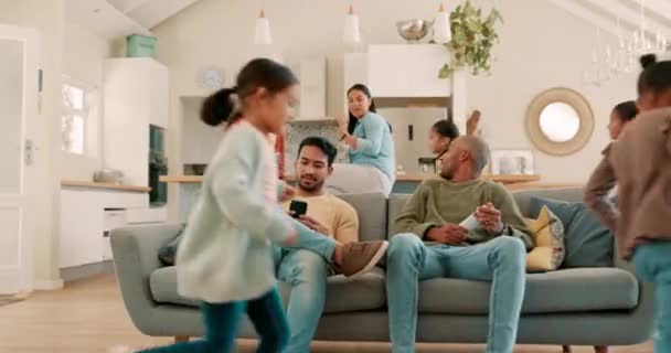 Happy, big family and living room fun with parents, children and running in a home. Young kids, excited and conversation with father, grandparents and mama together by a lounge sofa with a smile. - Video