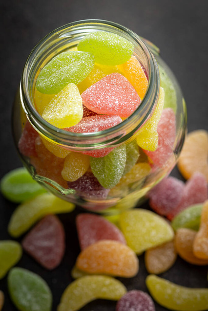 Mix of fruity jelly candy in jar on the black table. - Zdjęcie, obraz
