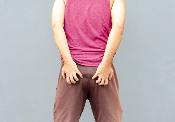 Asian man scratching itch with hand on buttock area, health care concept - Foto, Imagen