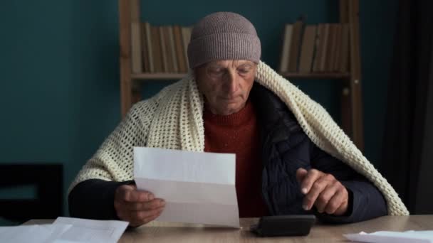 Αναστατωμένος φτωχός χρεοκοπημένος γέρος χωρίς χρήματα να παγώνουν σε εσωτερικούς χώρους στο σπίτι, μετρώντας το λογαριασμό θέρμανσης, διαβάζοντας την επιστολή ειδοποίησης διακοπής ρεύματος. Αντιγραφή χώρου - Πλάνα, βίντεο