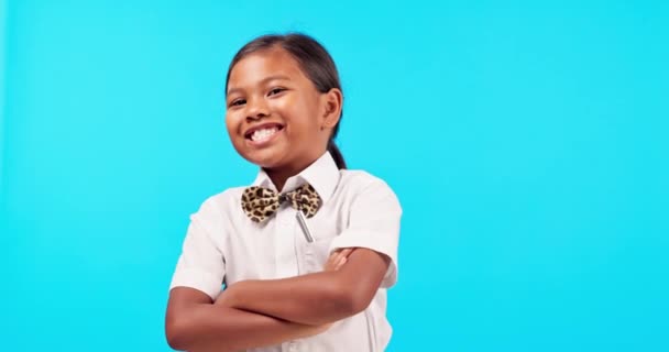 Fliege, und ein indisches Mädchen Kinderarme auf blauem Hintergrund isoliert im Atelier für Mode oder trendigen Stil gekreuzt. Porträt, Kinder und ein glückliches weibliches Kind posieren drinnen in einem stylischen Outfit. - Filmmaterial, Video