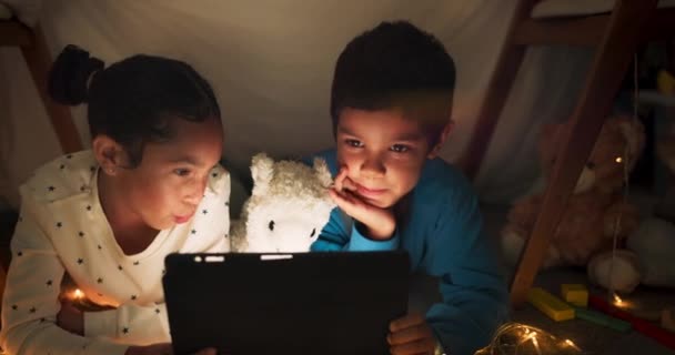 夜、タブレットや子供たちは、インターネットビデオ、ショーや夜にオンラインで映画について話しているテントハウスでストリーミング。闇、デジタル、兄弟や子供たちは夕方に漫画アプリを見てリラックスします. - 映像、動画