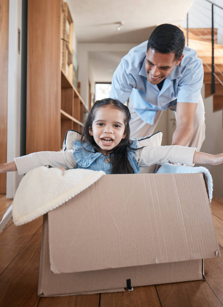 Dad, child and box, playing on floor in home with love and fantasy for happy family with smile and fun. Cardboard ride, playful bonding and father with girl in new house, games and adventure for kids. - Фото, изображение