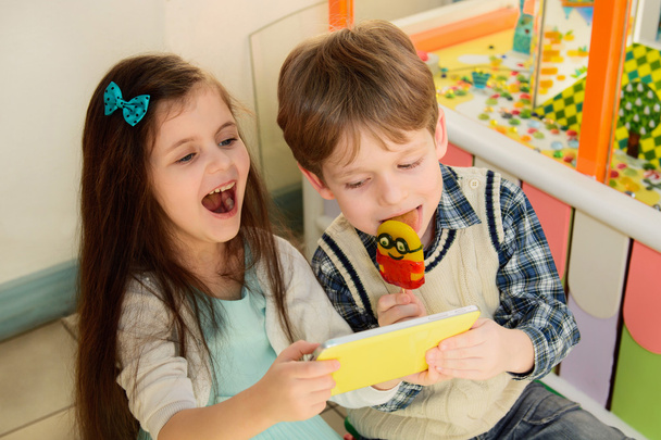 Niños felices usando Tablet PC en la tienda de dulces
 - Foto, imagen