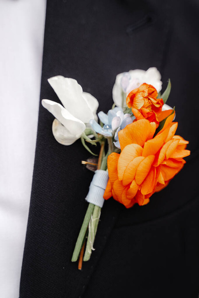 wedding boutonniere with white and red flowers on male black jacket - Foto, imagen