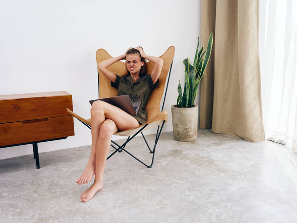 Freelancer feminino sentado na cadeira com laptop trabalho em casa raiva, moderno estilo de vida interior escandinavo elegante, espaço de cópia. Foto de alta qualidade - Foto, Imagem