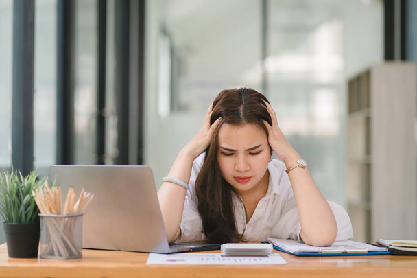 Tired frustrated young asian businesswoman feeling stressed holding head with hands, business problem failure concept - Photo, Image