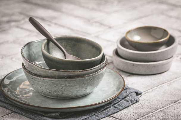 Gray stoneware plates and bowls on a rustic table, copy space - 写真・画像