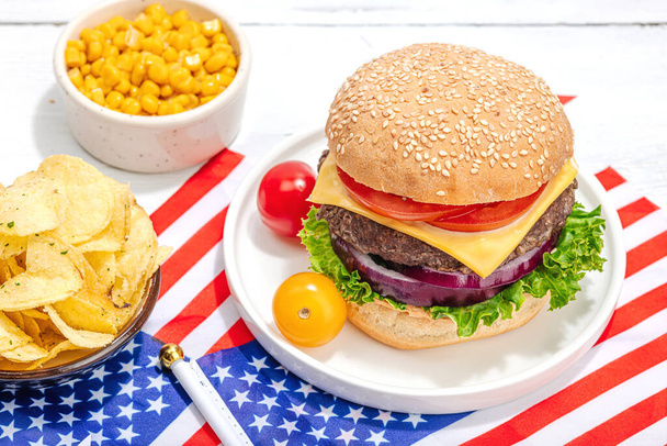 Homemade burgers. An American classic, traditional food for picnic, party or celebration Independence Day. Hard light, dark shadow, flat lay, white wooden background, close up - Zdjęcie, obraz