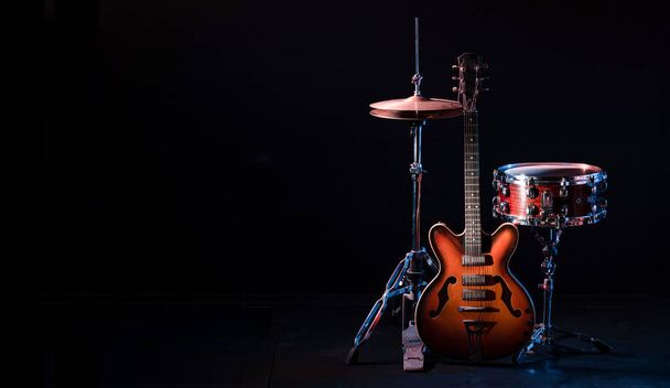 drum kit on stage on a dark background. Set of musical drums and guitars on stage. High quality photo - Photo, Image
