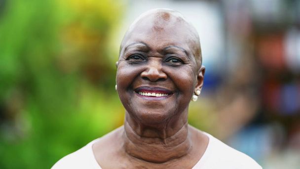 Portret starszej Afroamerykanki z uśmiechem na twarzy. Zbliżenie brazylijskiej czarnej starszej kobiety z radosnym wyrazem twarzy - Zdjęcie, obraz